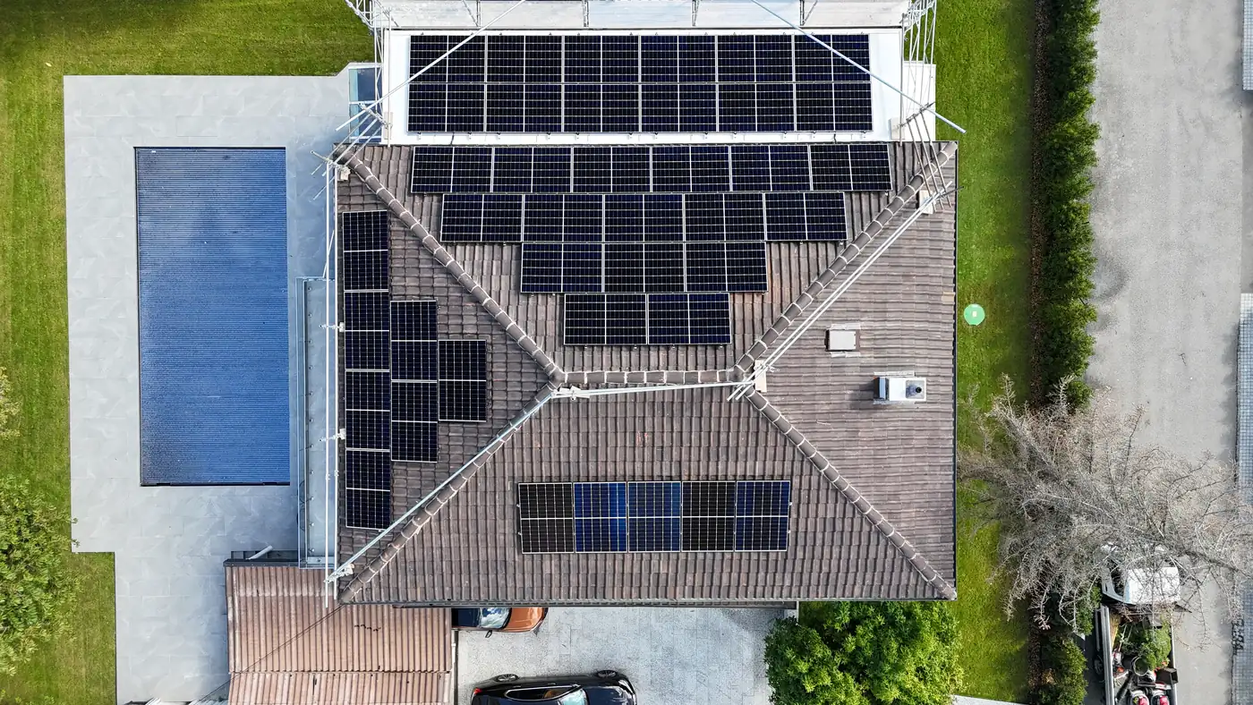Vue aérienne d’une villa avec piscine et installation solaire sur plusieurs pans de toiture